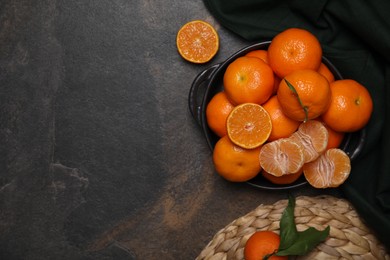 Photo of Fresh juicy tangerines on black table, flat lay. Space for text