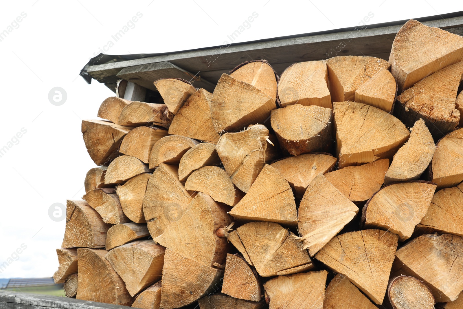 Photo of Pile of chopped firewood under roof outdoors