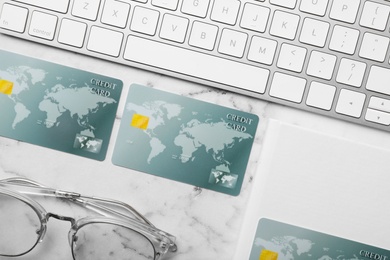 Flat lay composition with credit cards and computer keyboard on white marble background