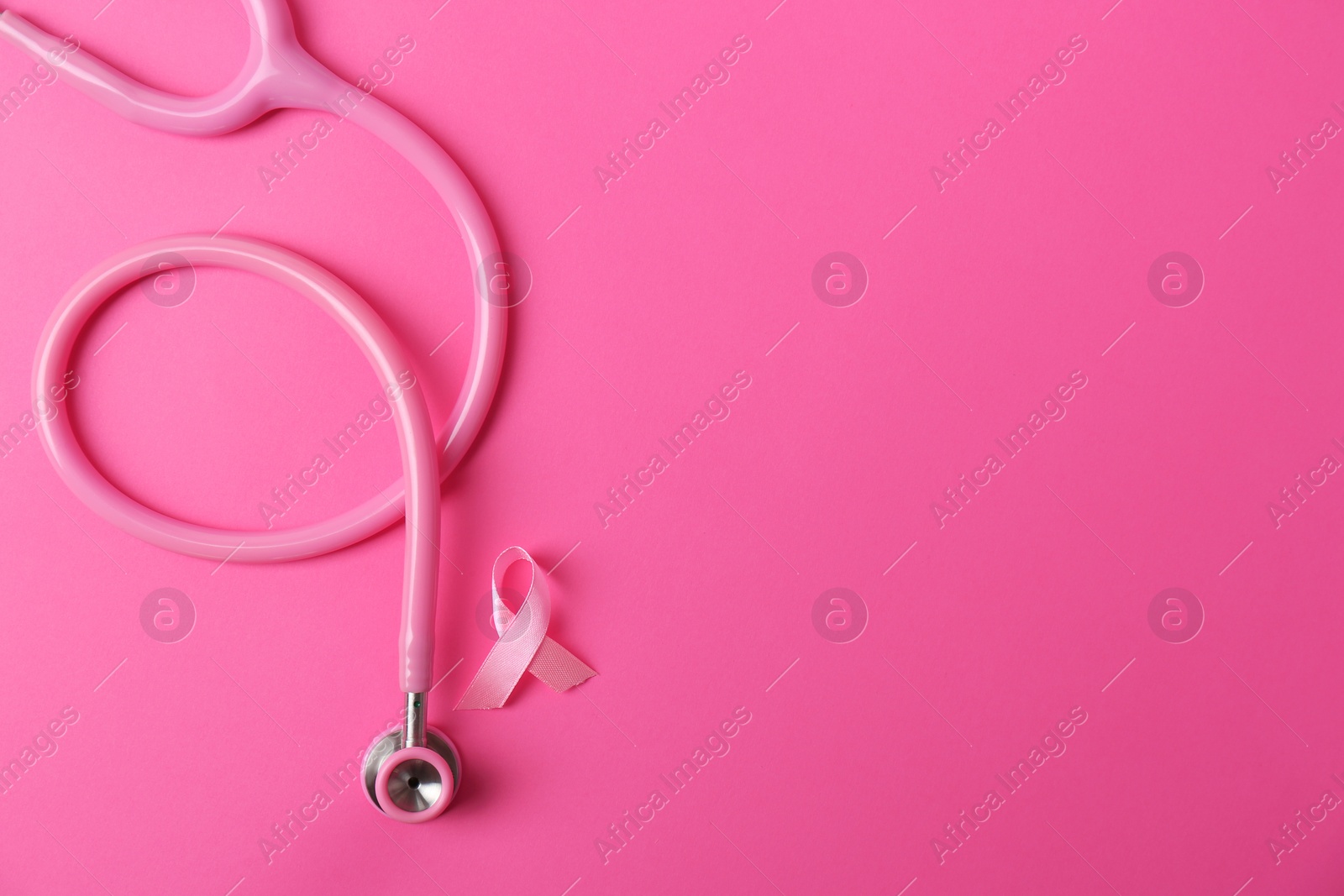 Photo of Pink ribbon and stethoscope on color background, top view with space for text. Breast cancer concept