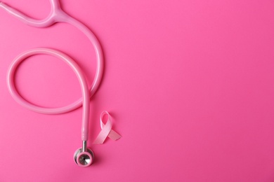 Pink ribbon and stethoscope on color background, top view with space for text. Breast cancer concept