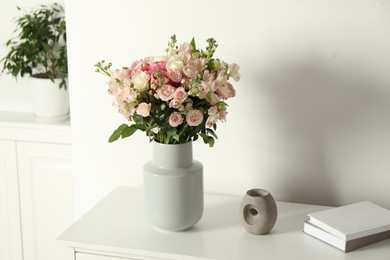 Photo of Beautiful bouquet of fresh flowers in vase on white table indoors