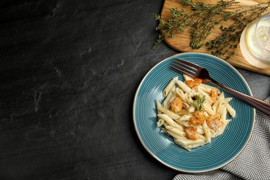 Photo of Delicious pasta with shrimps served on black table, flat lay. Space for text