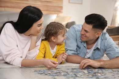 Happy family playing with puzzles on floor at home