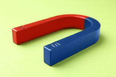 Red and blue horseshoe magnet on color background