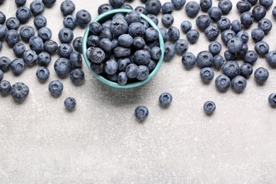 Tasty fresh blueberries on light grey table, flat lay. Space for text