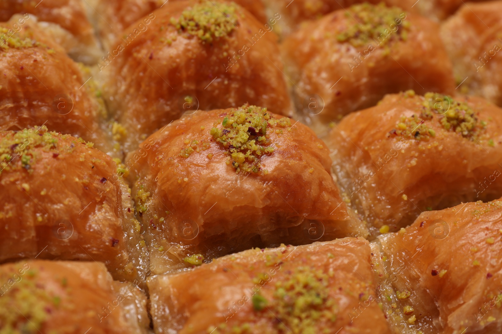 Photo of Delicious sweet baklava with pistachios as background, closeup