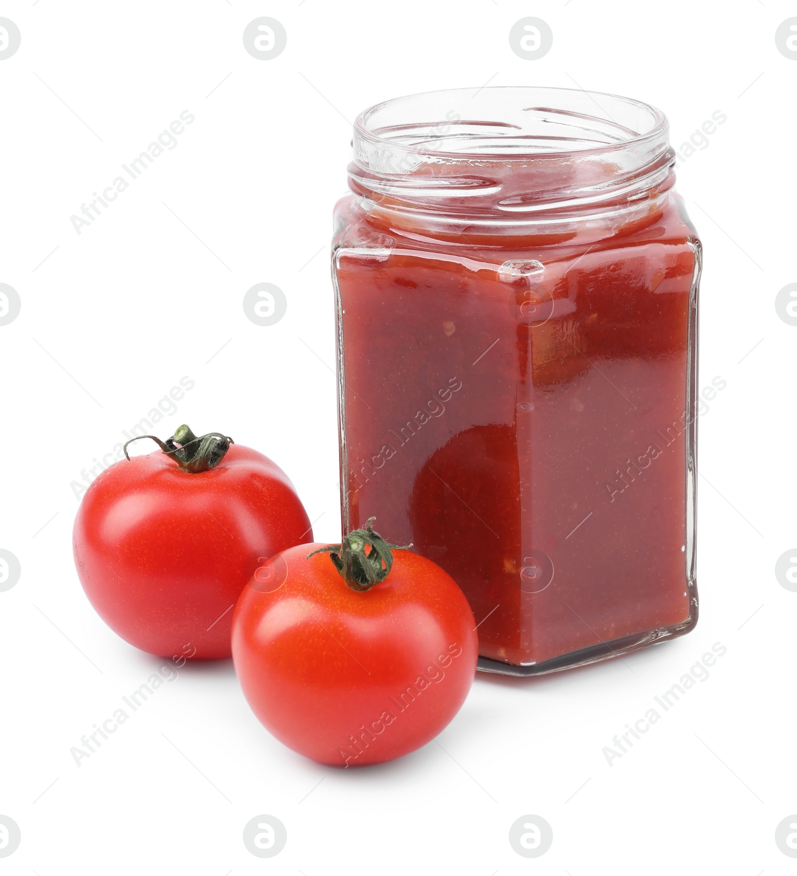 Photo of Organic ketchup in glass jar and fresh tomatoes isolated on white. Tomato sauce