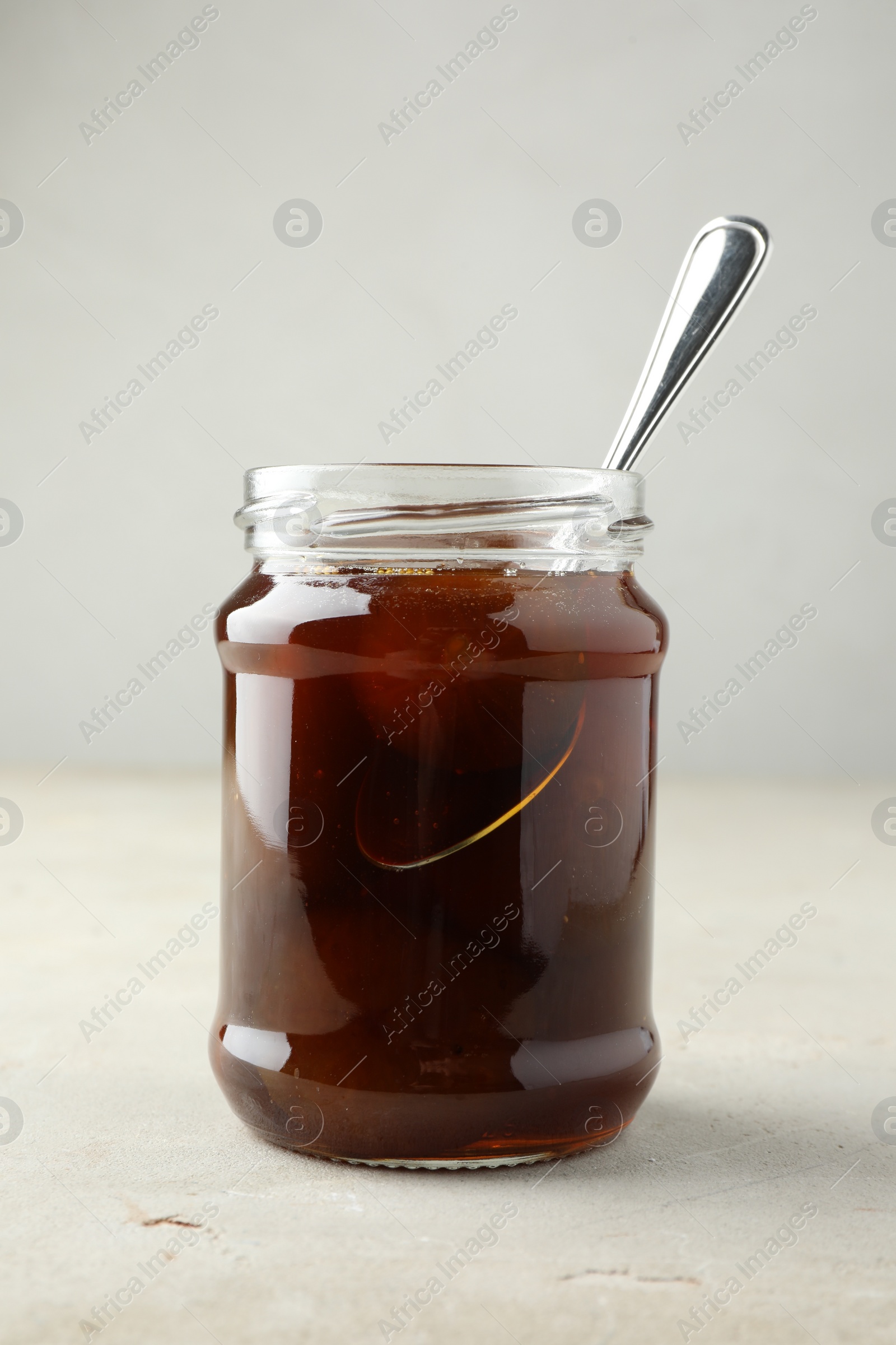 Photo of Jar of tasty sweet fig jam on light table