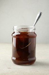 Jar of tasty sweet fig jam on light table