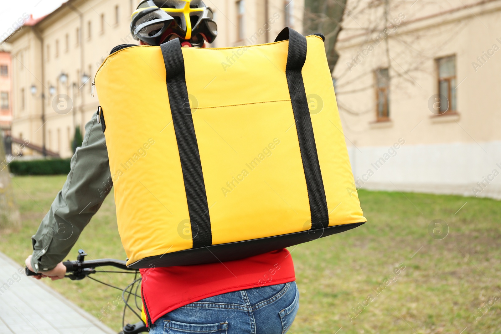 Photo of Courier with thermo bag riding bicycle outdoors. Food delivery service