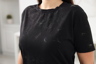 Woman with pet hair on her black clothers indoors, closeup