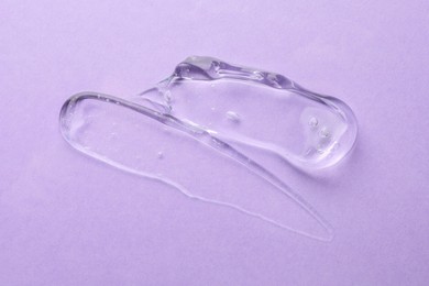 Photo of Clear cosmetic gel on violet background, top view