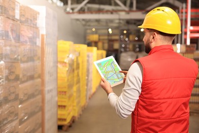 Image of Man with tablet working at warehouse, back view. Logistics center