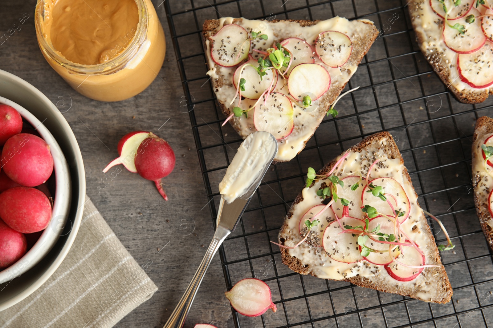 Photo of Tasty toasts with radishes, sprouts and chia seeds served on table, top view