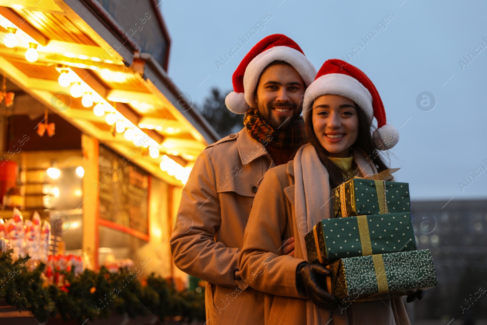 Photo of Lovely couple with Christmas presents at winter fair