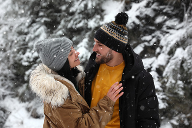 Lovely couple outdoors on snowy day. Winter vacation