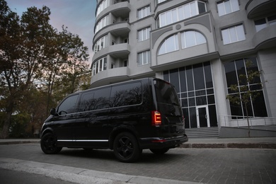 Black delivery van parked on street near building