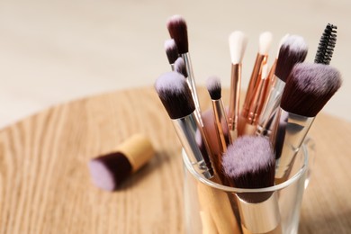 Photo of Set of professional makeup brushes on wooden table. Space for text