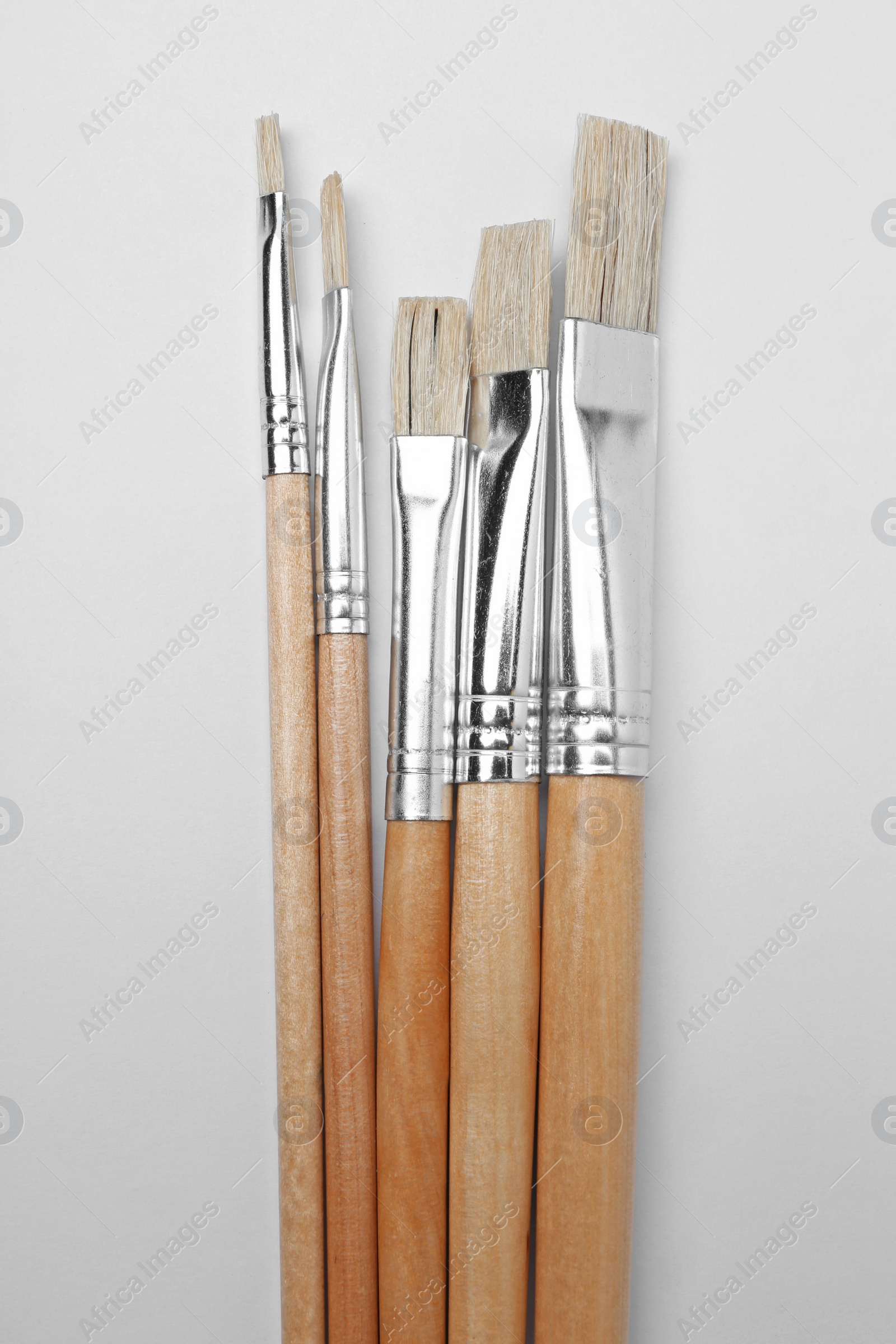 Photo of Different paint brushes on white background, top view