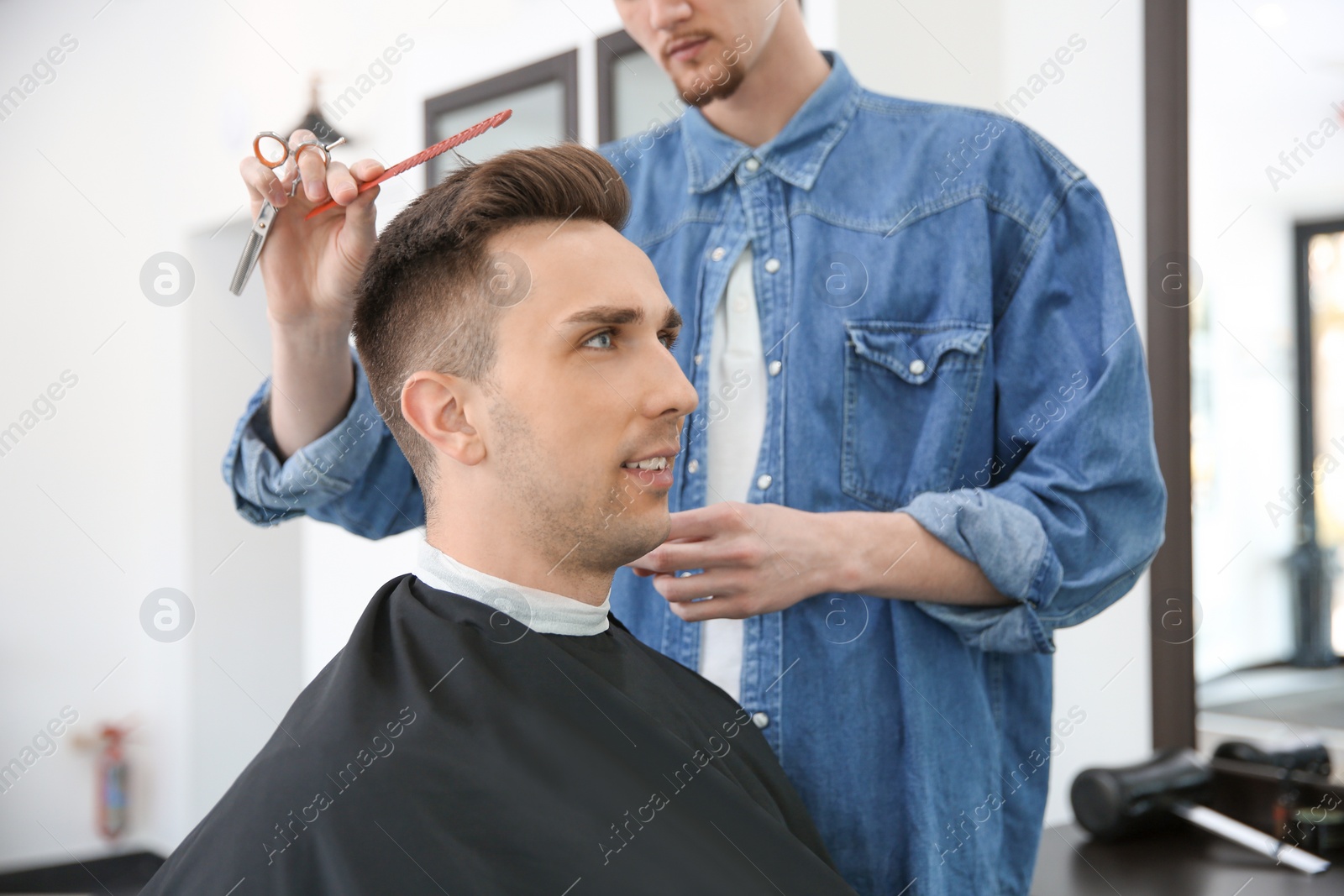 Photo of Professional barber working with client in hairdressing salon. Hipster fashion