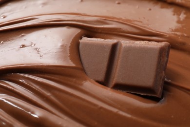 Tasty milk chocolate paste and pieces as background, closeup