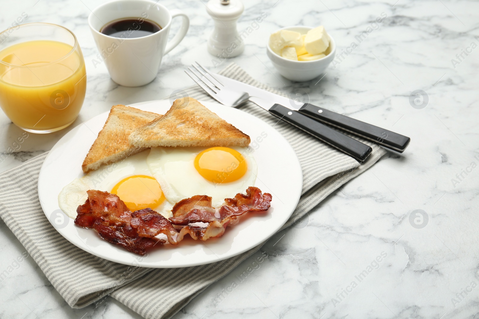 Photo of Delicious breakfast with sunny side up eggs served on white marble table. Space for text