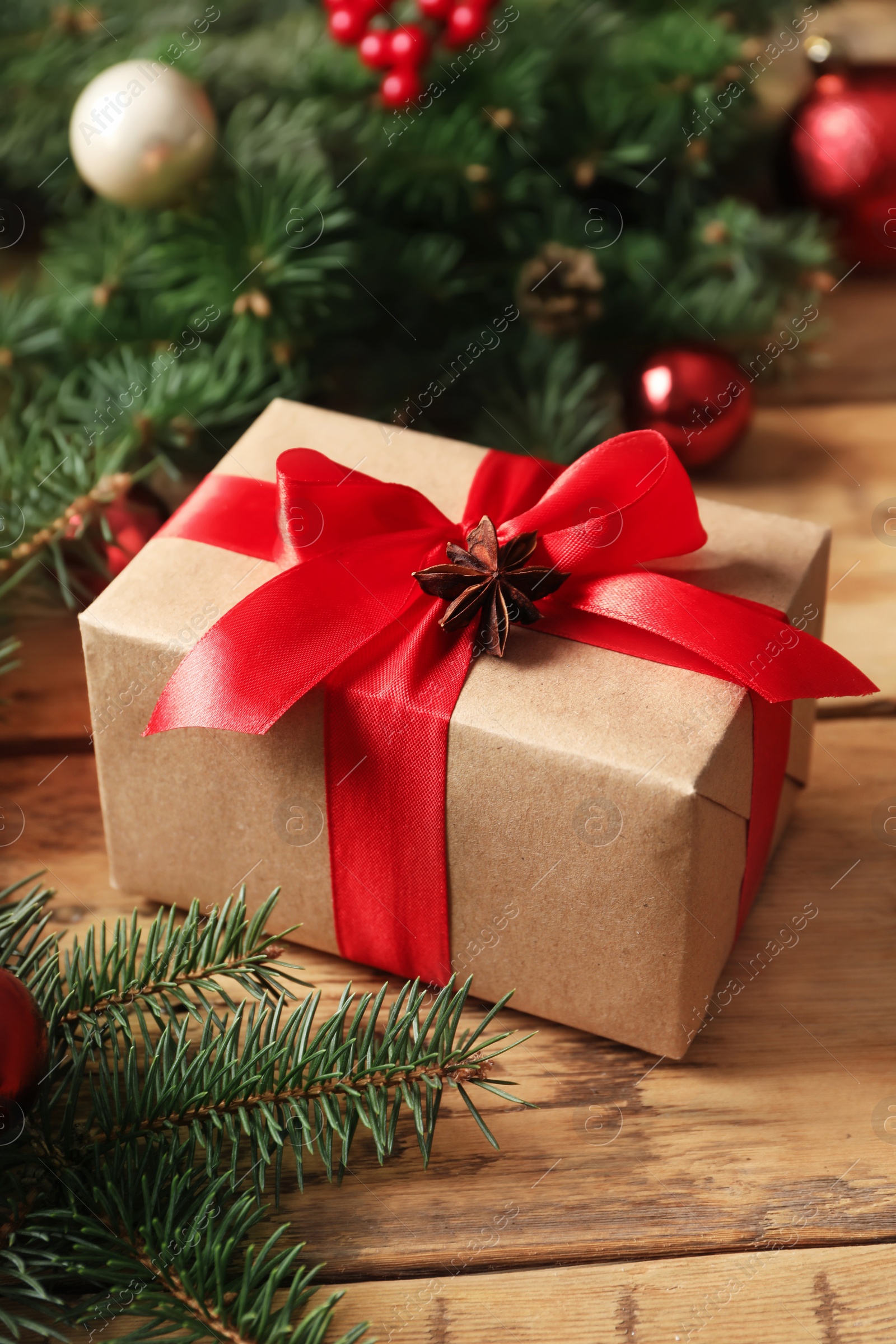 Photo of Christmas gift box on wooden table, closeup