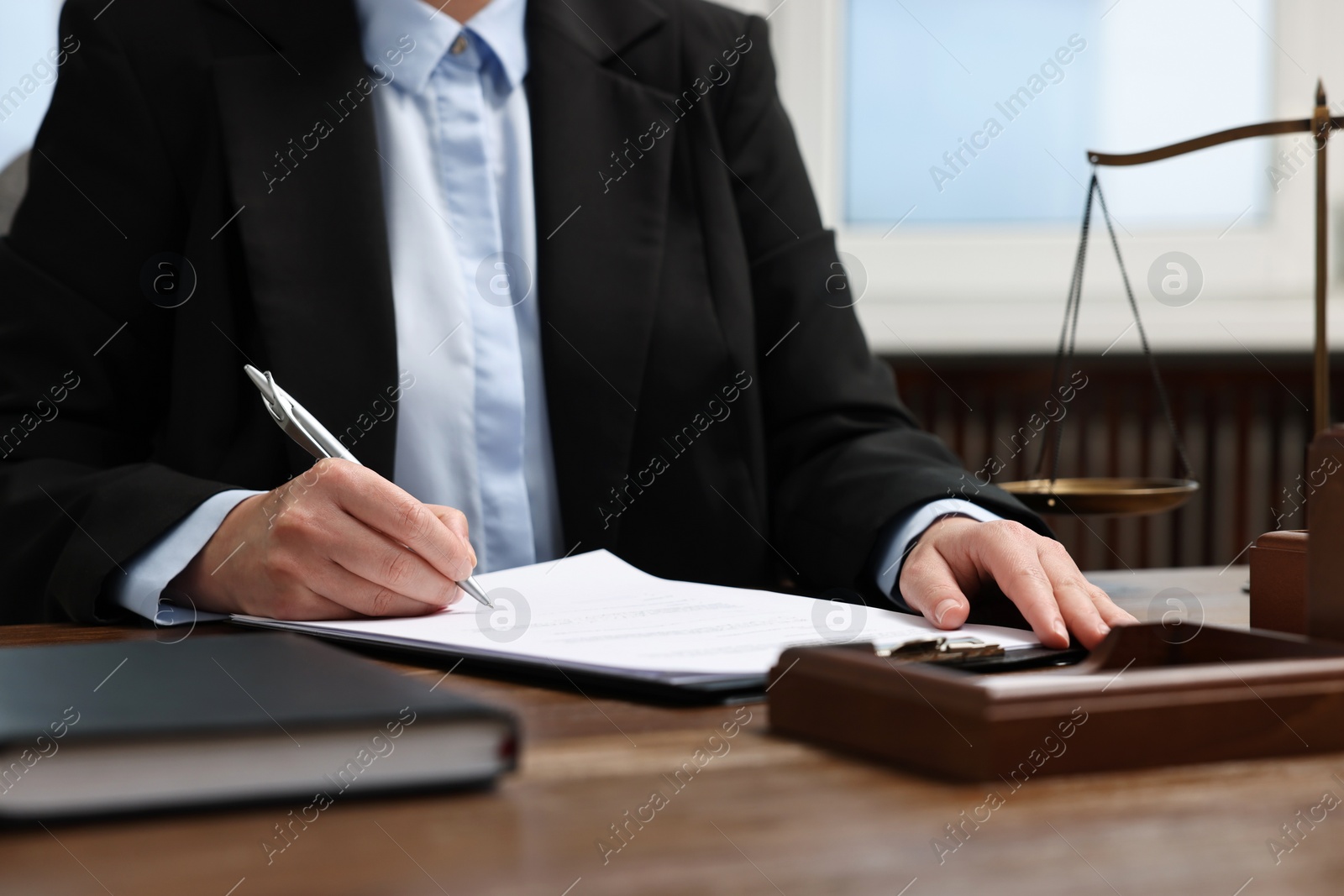 Photo of Lawyer working at wooden table in office, closeup