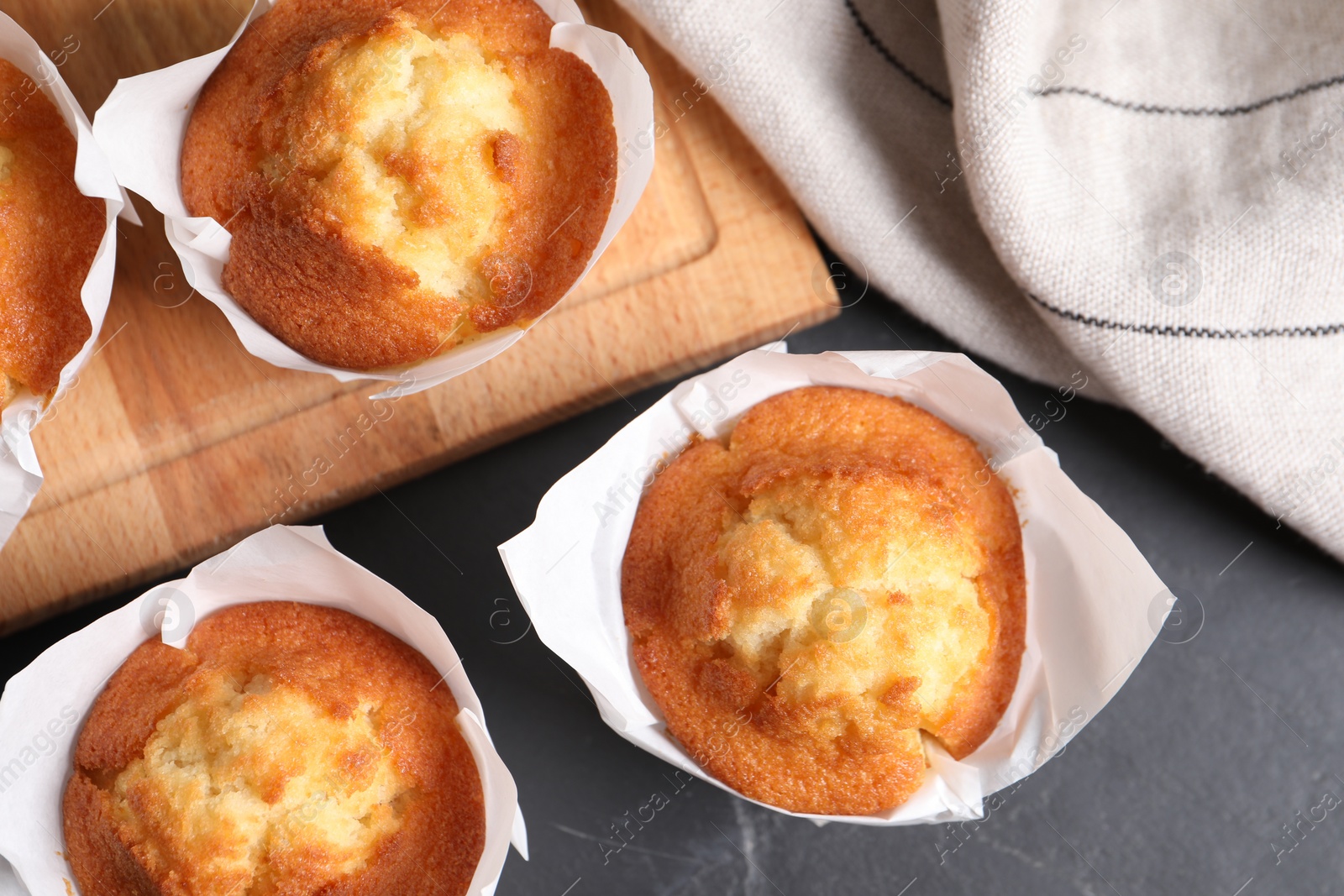 Photo of Tasty muffins on grey table, flat lay. Fresh pastry