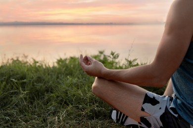 Photo of Man meditating near river, closeup. Space for text