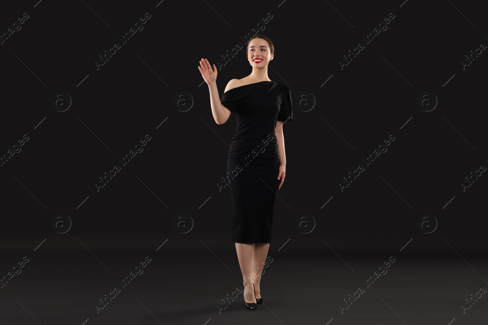 Photo of Beautiful young woman in elegant dress on black background