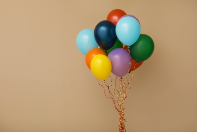 Photo of Bunch of bright balloons on color background, space for text. Celebration time