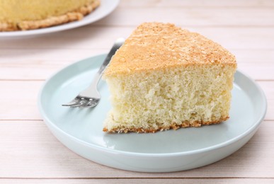 Photo of Piece of tasty sponge cake on white wooden table, closeup