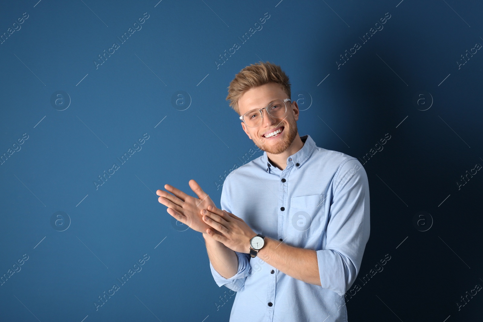 Photo of Portrait of handsome young man on blue background. Space for text