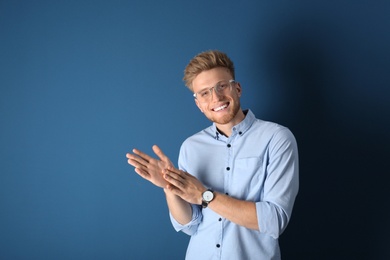 Portrait of handsome young man on blue background. Space for text