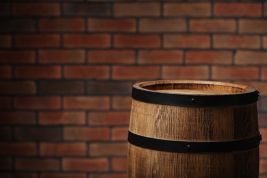 Photo of Wooden barrel near brick wall. Space for text
