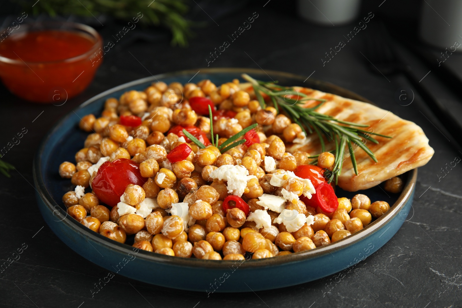 Photo of Delicious fresh chickpea salad on black table