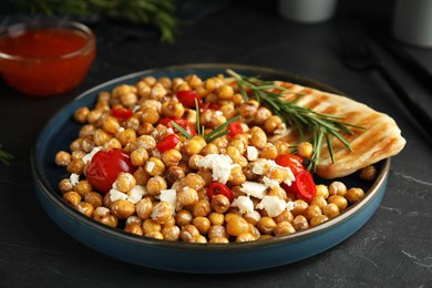 Photo of Delicious fresh chickpea salad on black table