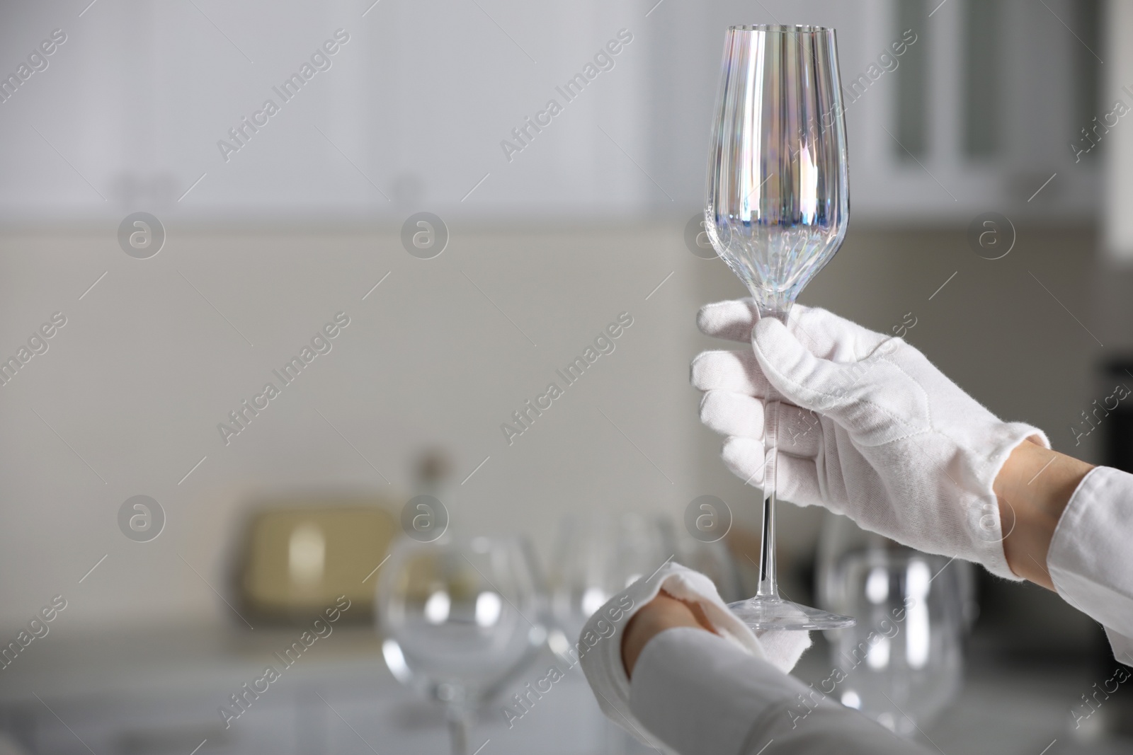 Photo of Person in white gloves checking cleanliness of glass indoors, closeup. Space for text