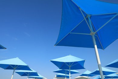 Photo of Bright beach umbrellas against blue sky on sunny day