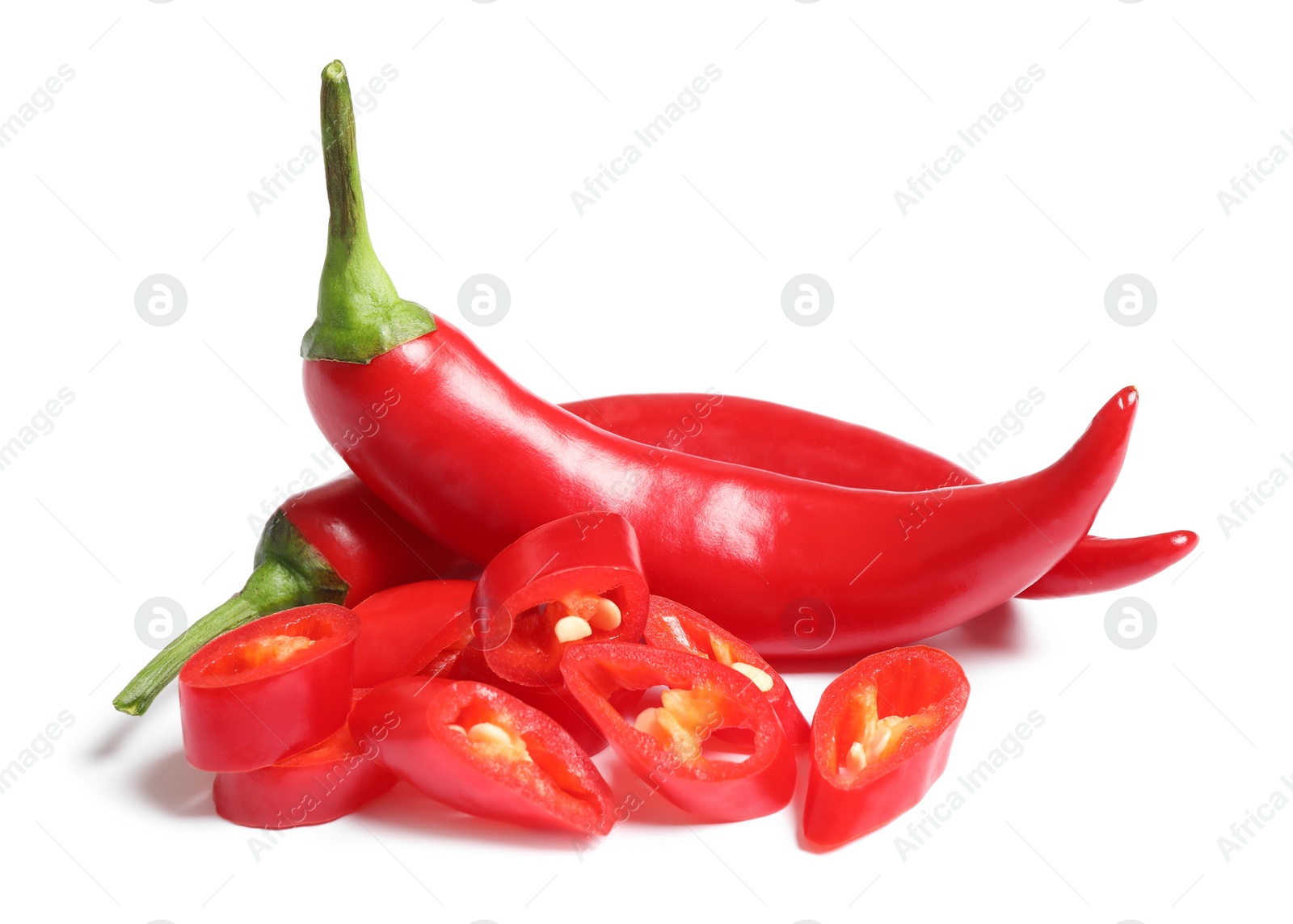 Photo of Cut and whole red hot chili peppers on white background