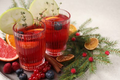 Photo of Aromatic Christmas Sangria in glasses served on light table, space for text
