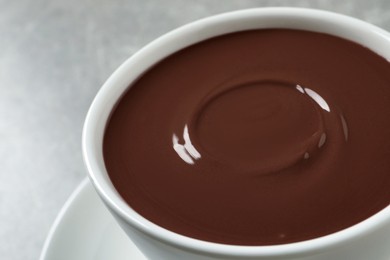 Yummy hot chocolate in cup on light grey background, closeup