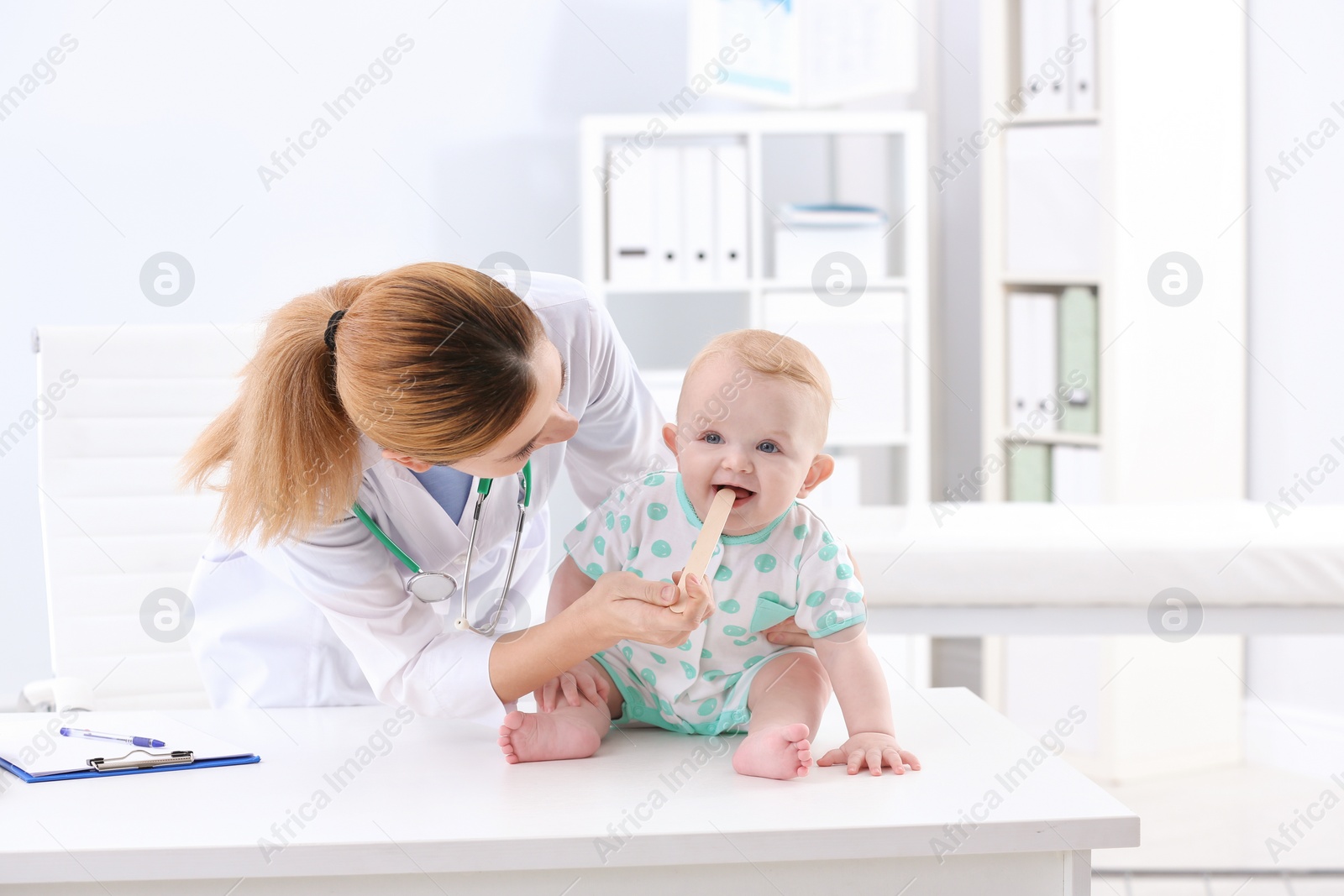 Photo of Children's doctor examining baby's throat in hospital