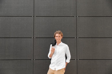 Photo of Portrait of handsome young man leaning to wall outdoors