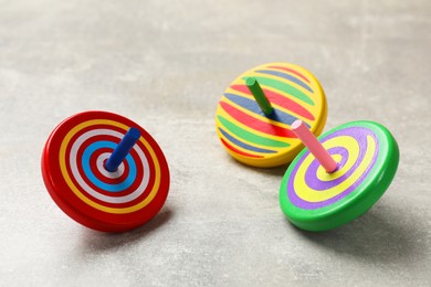 Bright spinning tops on grey textured background, closeup