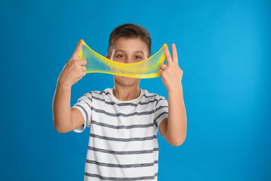 Photo of Little boy with slime on blue background