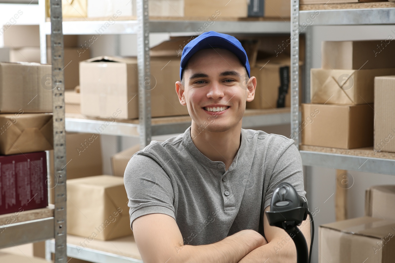 Photo of Post office worker near scanner reading parcel barcode indoors