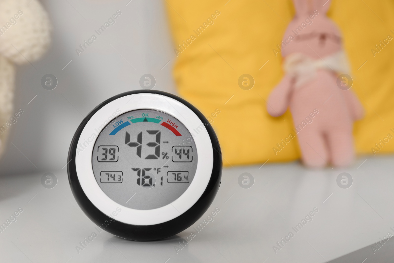 Photo of Digital hygrometer with thermometer on white table. Space for text